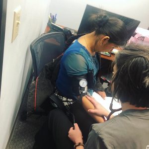 Ventanilla de Salud: Nursing assistant taking blood pressure.